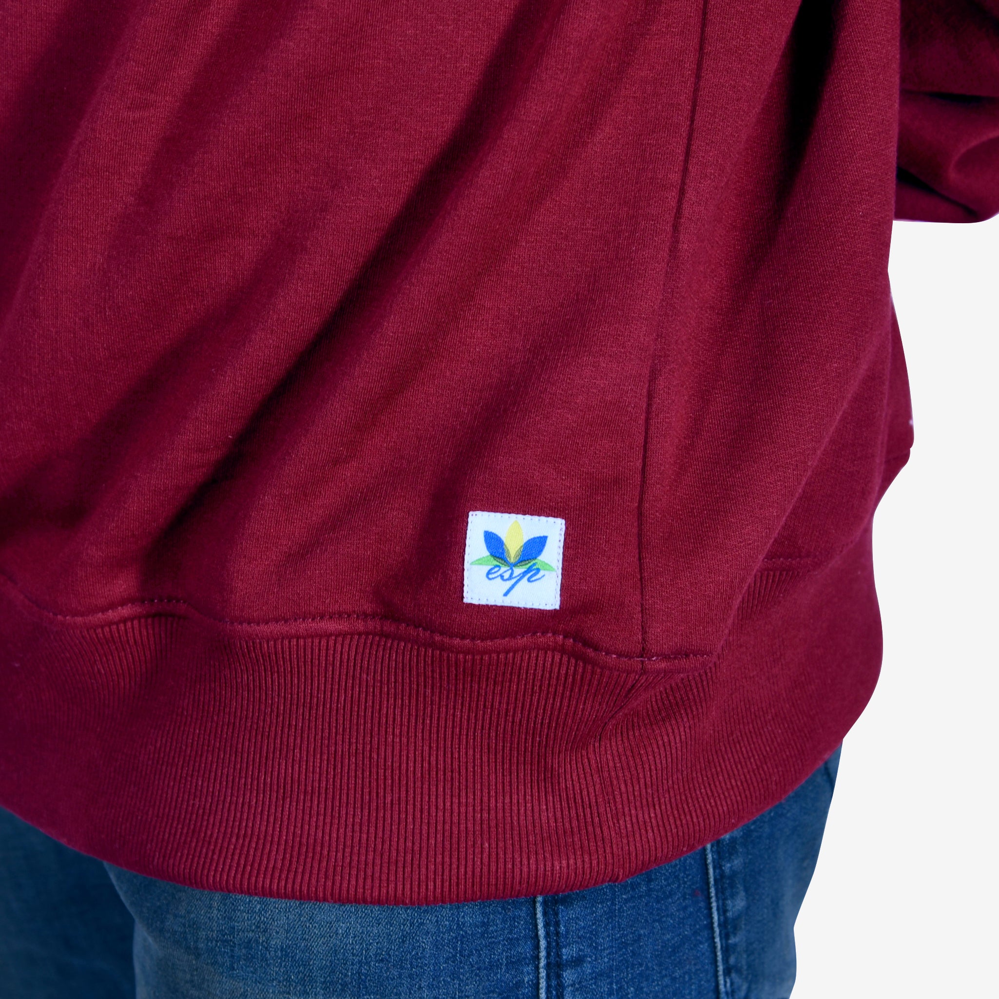 Detailed view of the fabric and fit of an oversized maroon sweatshirt