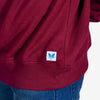 Detailed view of the fabric and fit of an oversized maroon sweatshirt